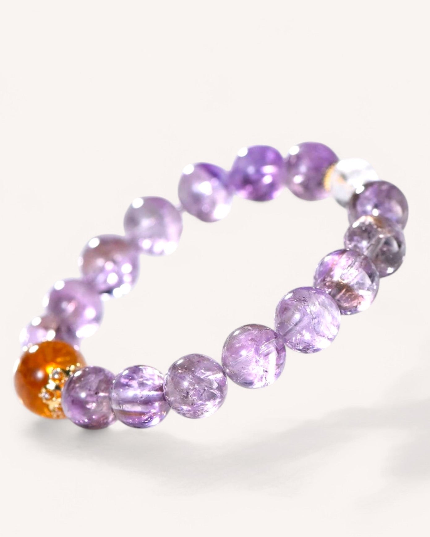 A close-up of the Amethyst & Yellow Azeztulite Fortune Energy Bracelet, featuring faceted amethyst and yellow azeztulite beads designed to attract prosperity and enhance spiritual clarity.