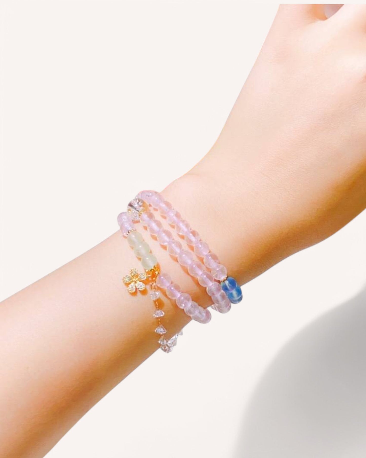 A stunning multi-layer Rose Quartz bracelet featuring Golden Rutilated Quartz, Aquamarine, and Prehnite, elegantly worn on a wrist to enhance love, emotional healing, and spiritual balance.
