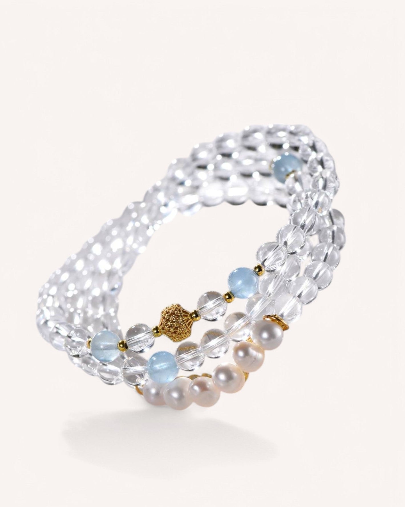 This elegant multi-layer crystal bracelet combines White Quartz, Aquamarine, and Pearls to promote inner peace, intuition, and emotional well-being.