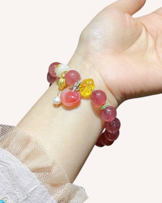 Strawberry Quartz and Honey Amber bracelet worn on wrist for emotional healing and vitality