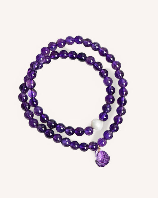 Elegant Amethyst Double-Wrap Bracelet featuring deep violet amethyst beads, a white jade accent, and a dangling amethyst charm. Designed for spiritual healing, wisdom, and emotional balance.