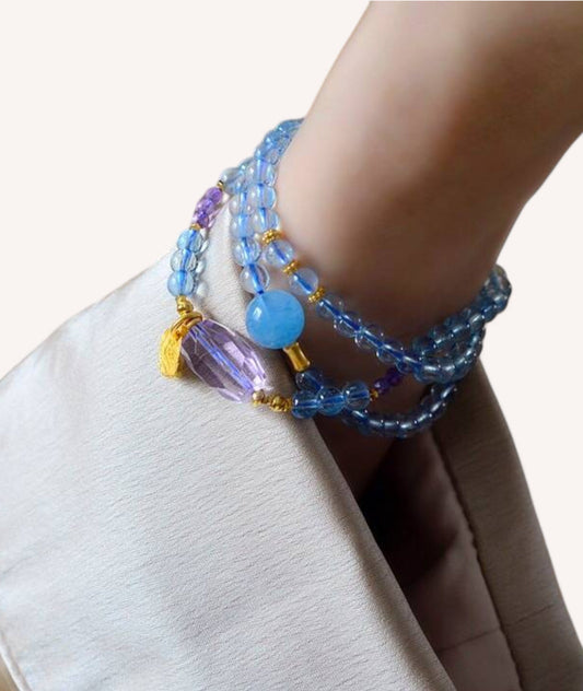 Model wearing aquamarine and amethyst wrap bracelet for emotional balance and intuition