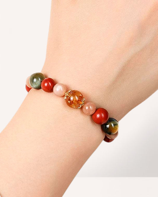 Woman wearing a crystal bracelet featuring Black Obsidian, Citrine, Red Agate, and Sunstone for grounding, vitality, and energy protection.