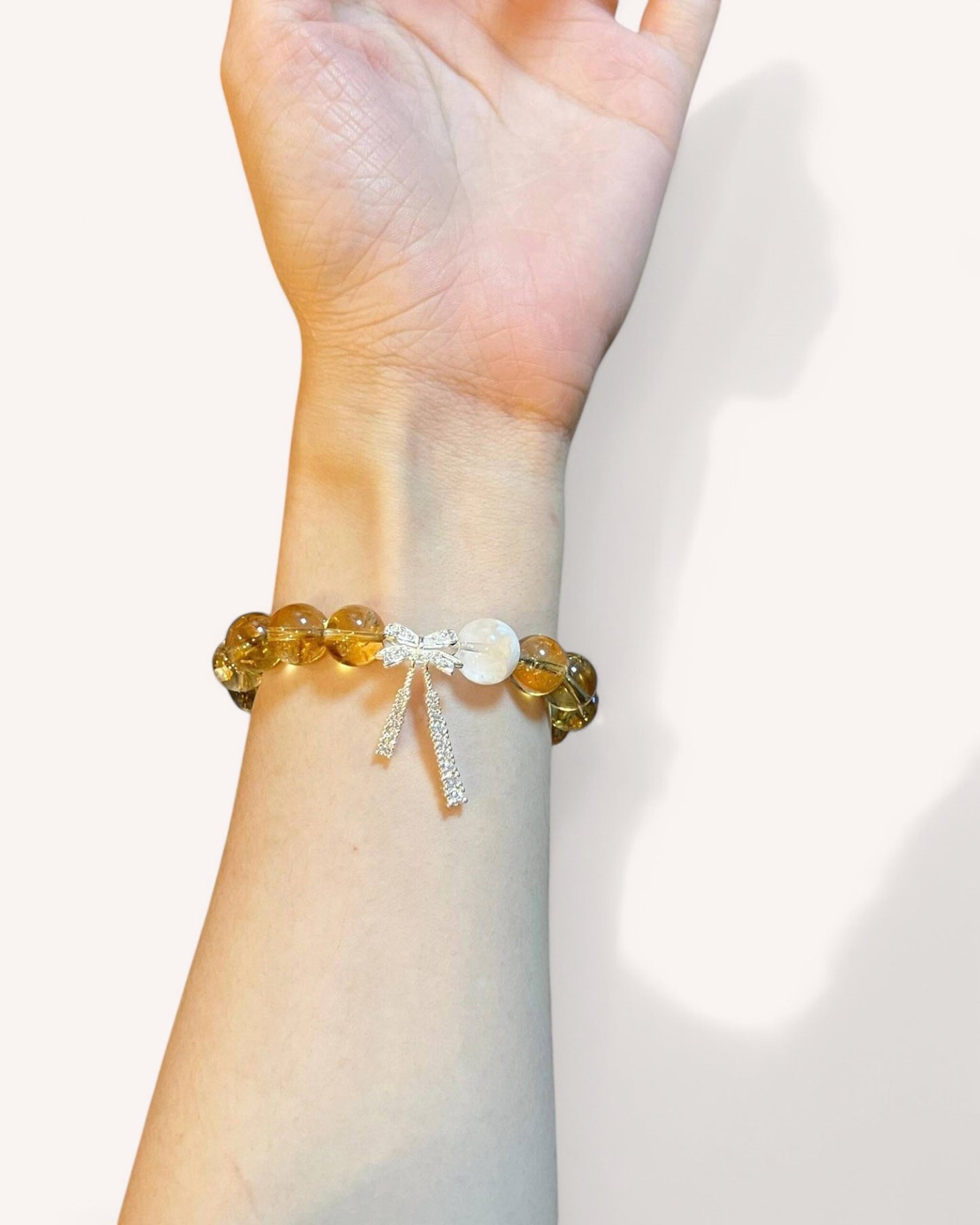 Citrine Manifestation Bracelet on Wrist – A natural crystal bracelet featuring Citrine beads and an elegant bow charm. Designed to attract success, abundance, and confidence, this energy bracelet enhances motivation and clarity.