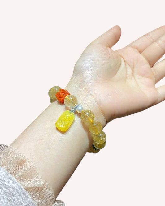 Wrist view of the prosperity bracelet made with Rutilated Quartz, Amber, and South Red Agate, symbolizing vitality, abundance, and confidence.
