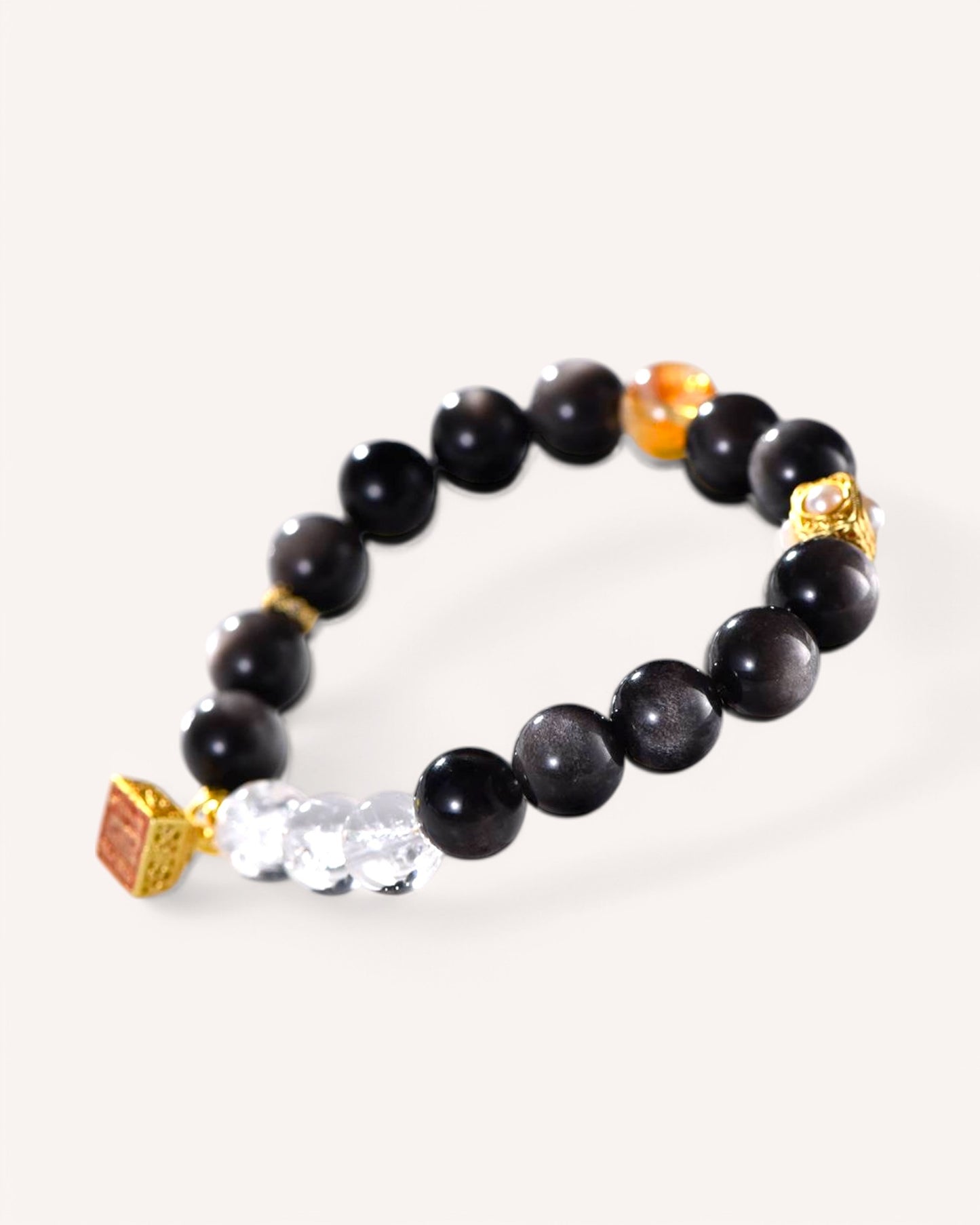 Flat lay of spiritual healing bracelet with Silver Sheen Obsidian and White Quartz for prosperity and clarity