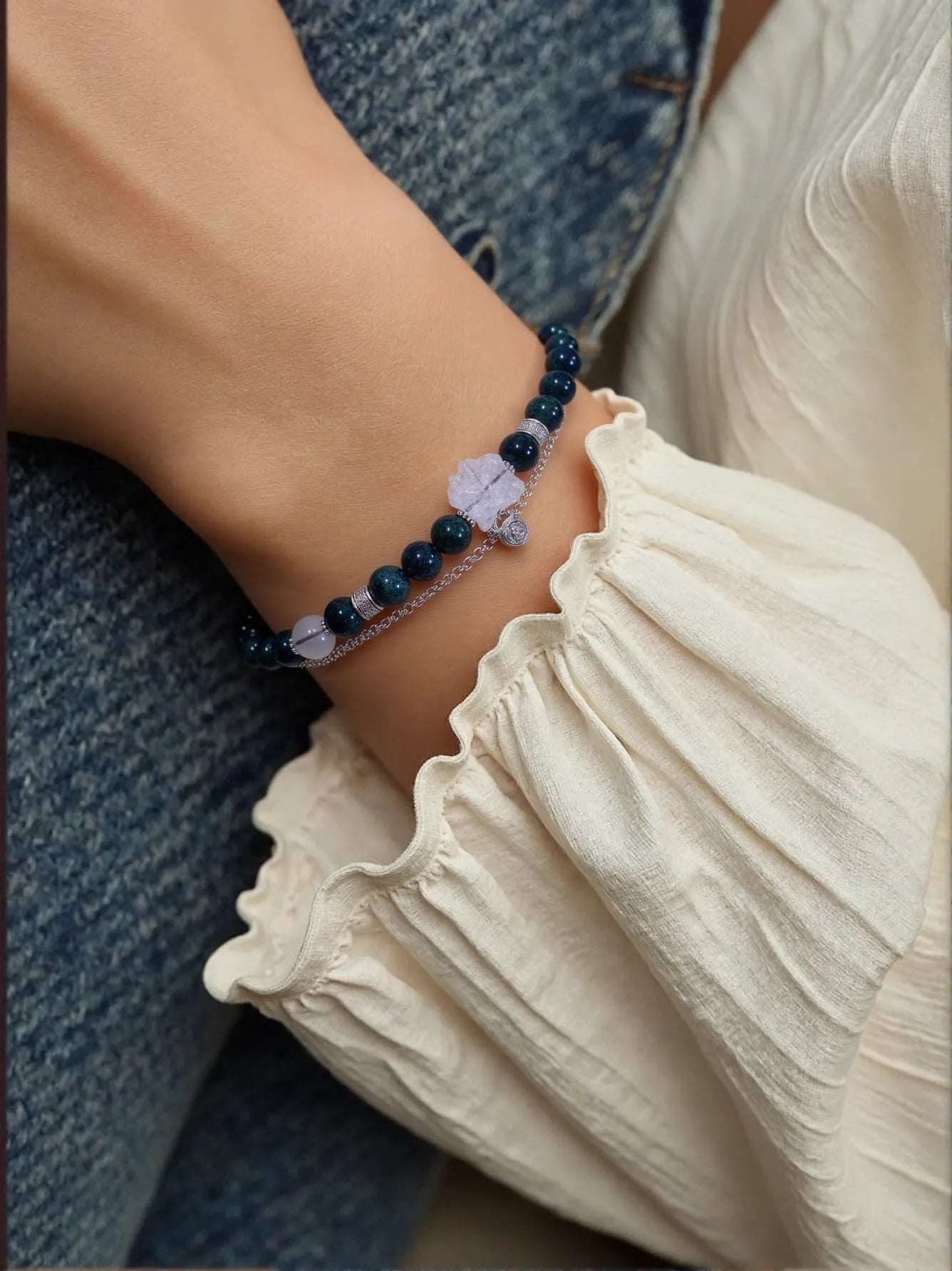 Model wearing White Quartz and Gray Moonstone bracelet with silver charm, designed for spiritual protection and emotional healing.
