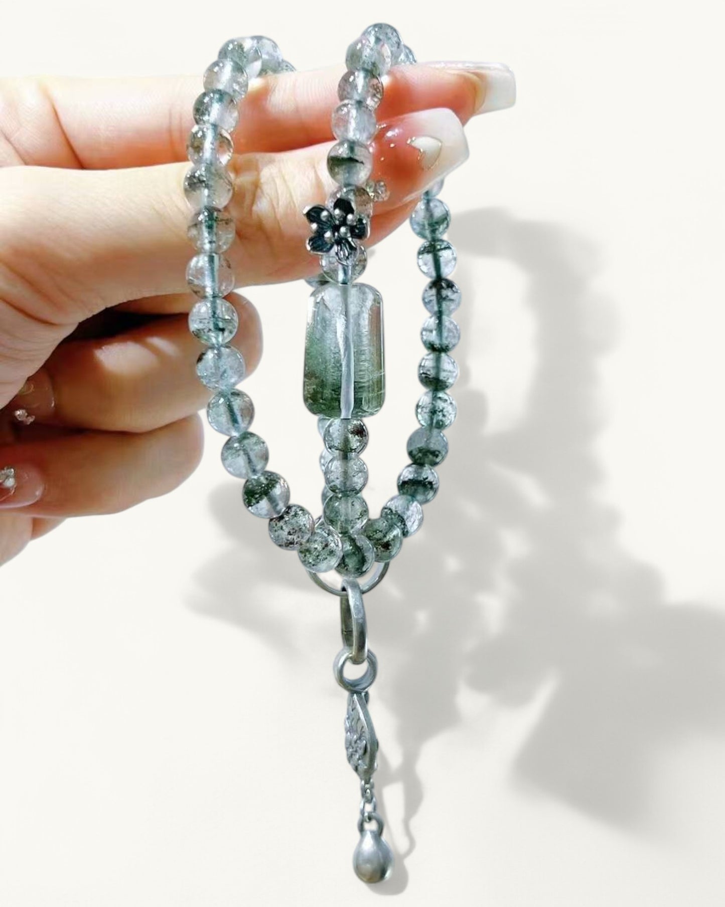 Healing Brazilian Green Phantom bracelet with charm, held in hand to showcase double-layered design and grounding energy