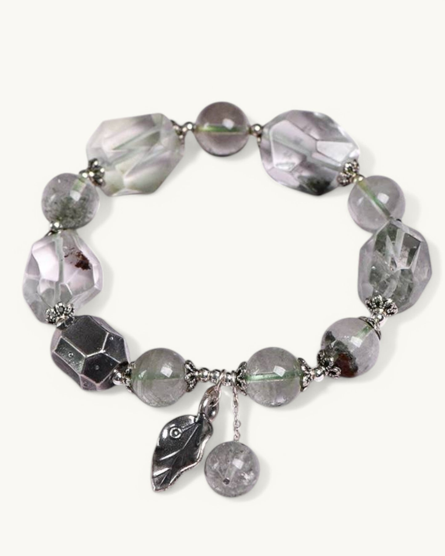 Flat lay of Green Phantom healing bracelet with leaf and drop charms, ideal for spiritual growth and protection.