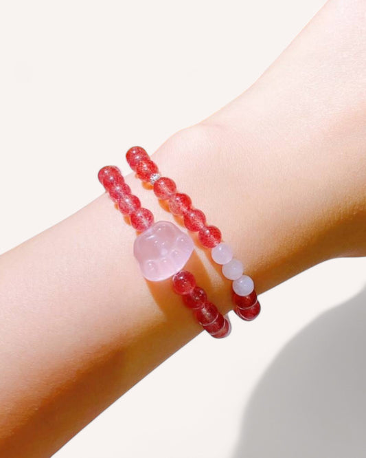 Model wearing Strawberry Quartz and Rose Quartz bracelet with heart charm, promoting love and self-care