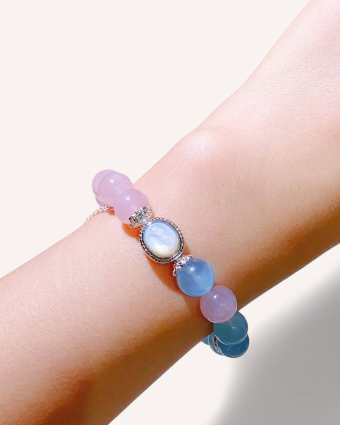 Tranquility and intuition bracelet made of Rose Quartz, Aquamarine, and Blue Moonstone worn on wrist, symbolizing love, peace, and spiritual harmony