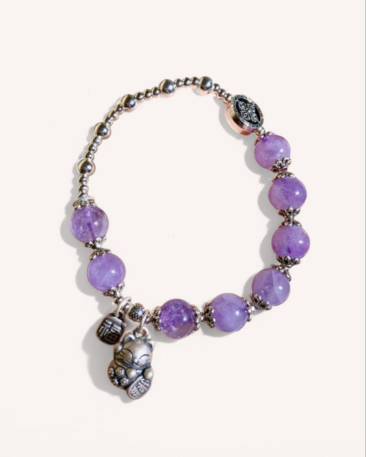 Angled view of the Lavender Amethyst Fortune Cat Bracelet, crafted with lavender amethyst beads and a lucky cat charm to attract fortune and positive energy.