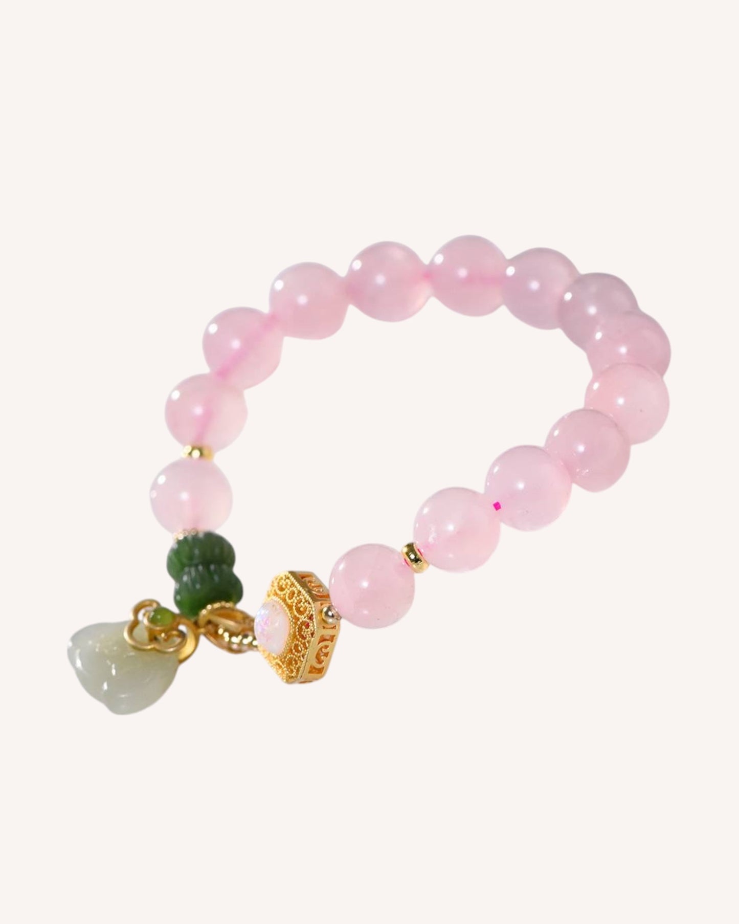 Side view of healing Rose Quartz bracelet with Hetian Jade beads and gold prosperity charm.