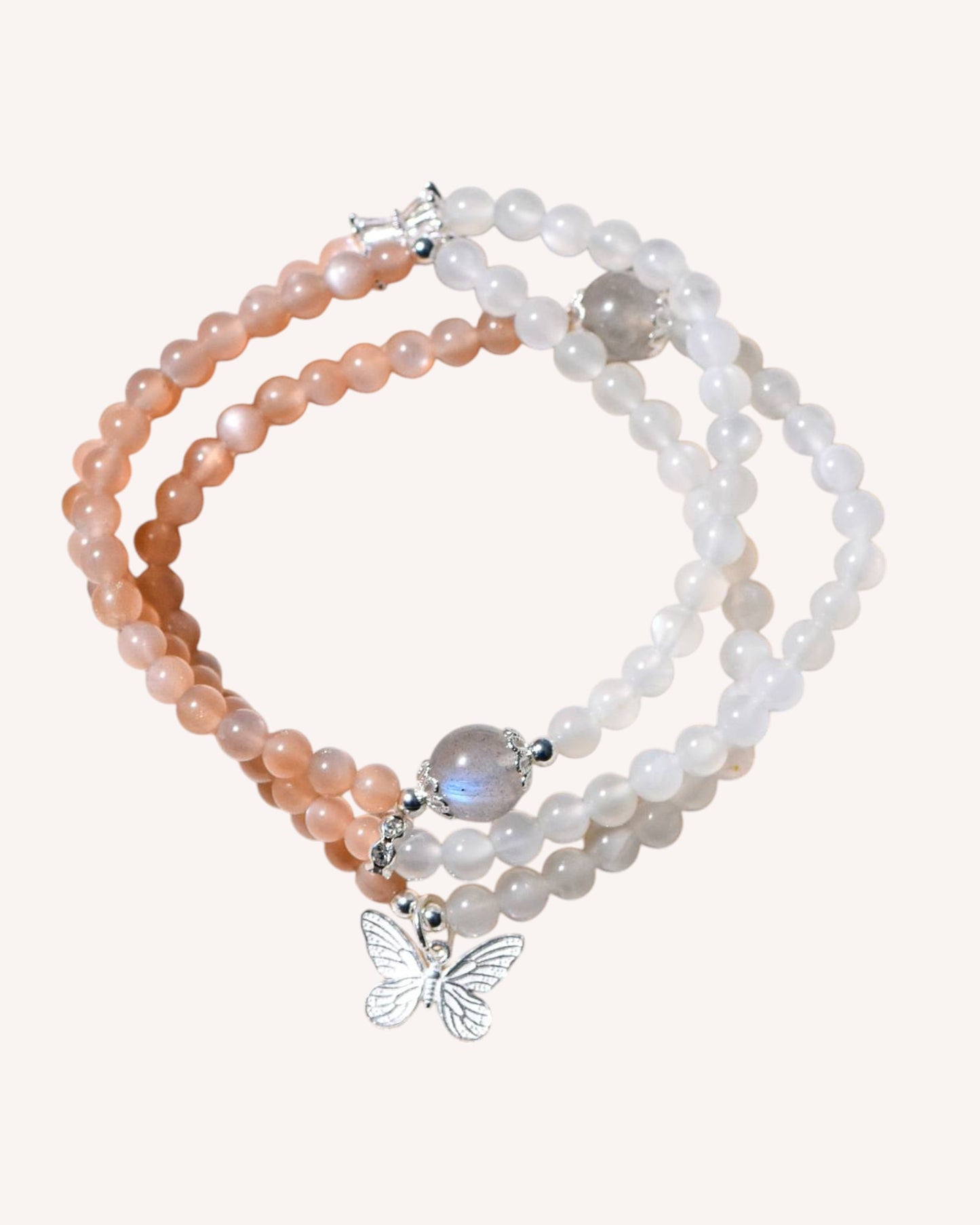 Multi-layer bracelet made of Orange, White, and Gray Moonstone with silver butterfly charm, promoting intuition, feminine energy, and emotional strength