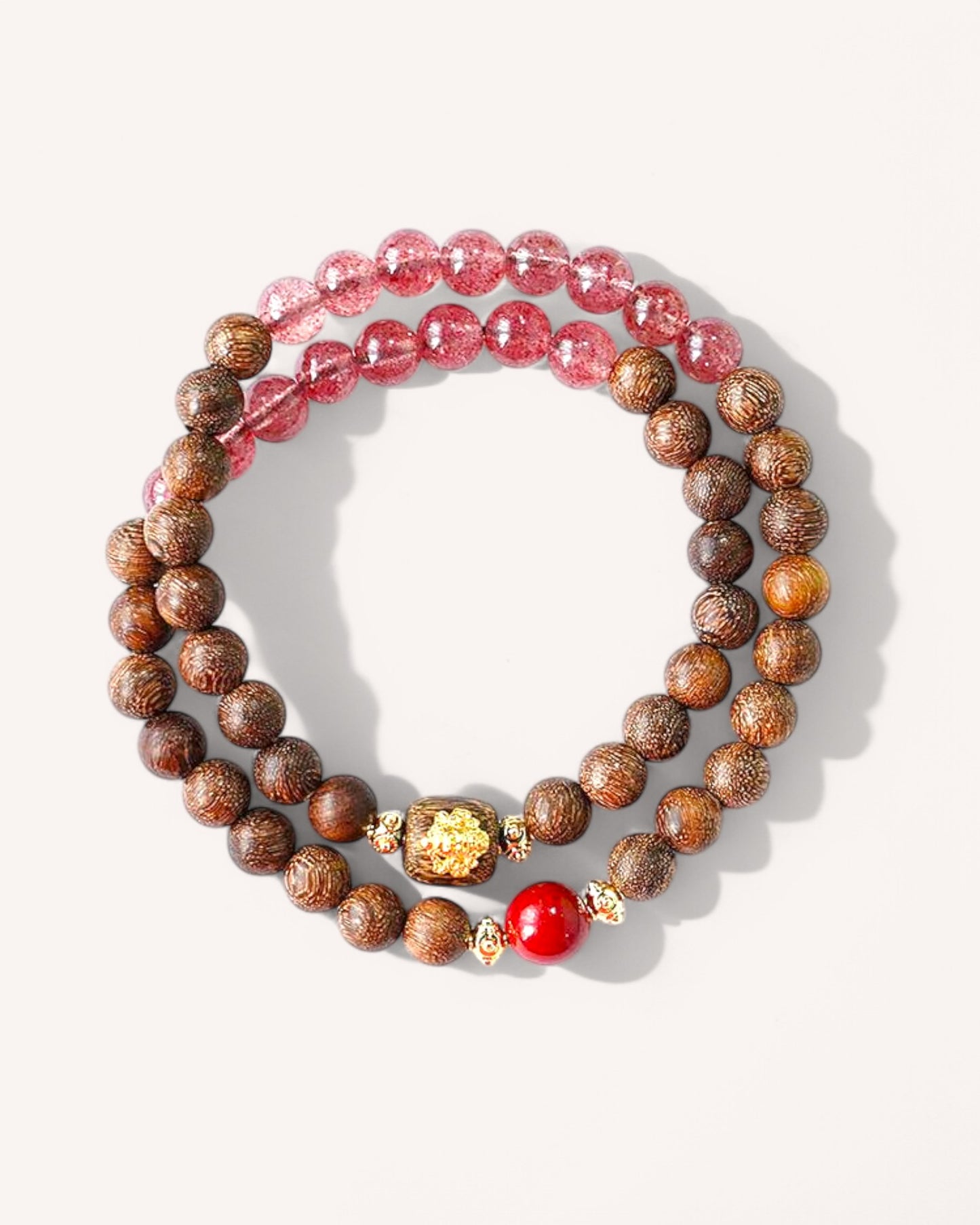 Layered view of wealth and balance bracelet with Cinnabar, Strawberry Quartz, and Sandalwood beads.