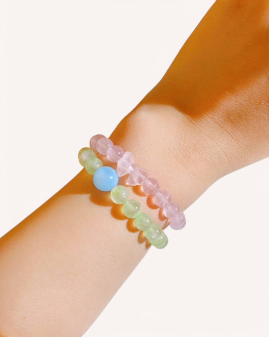 Crystal bracelet with rose quartz, beeswax, and aquamarine shown on wrist, ideal for emotional healing, peace, and inner harmony.