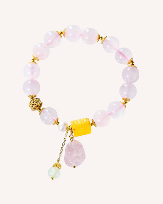 Rose Quartz and Honey Amber bracelet with golden accents and dangling gemstone charms, promoting emotional healing and love.