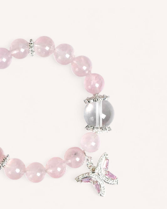 Elegant Rose Quartz bracelet with a butterfly charm and White Quartz crystal, designed for self-love, harmony, and transformation.