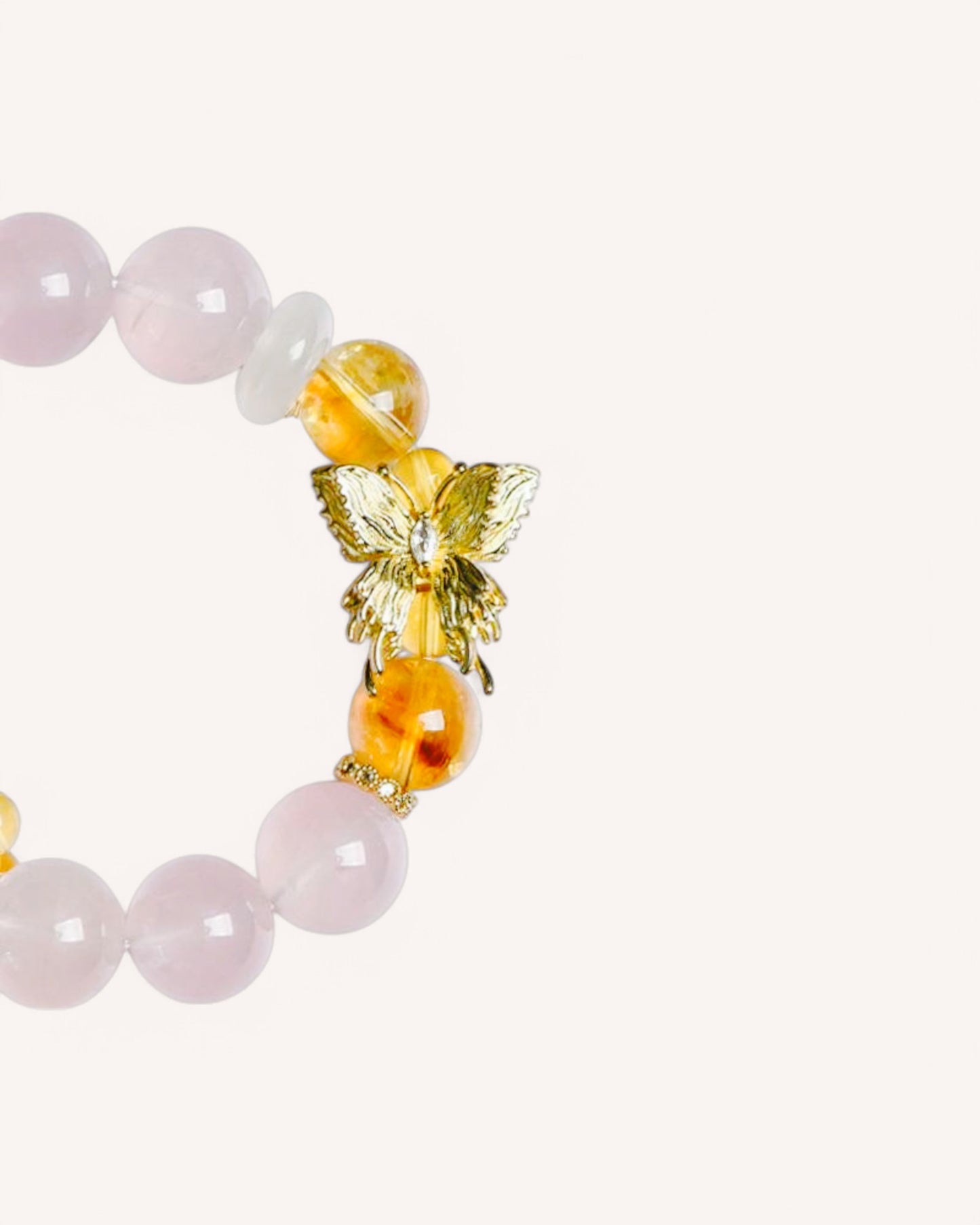 Close-up detail of Rose Quartz and Yellow Azeztulite bracelet featuring a golden butterfly charm for love attraction and positive energy alignment.