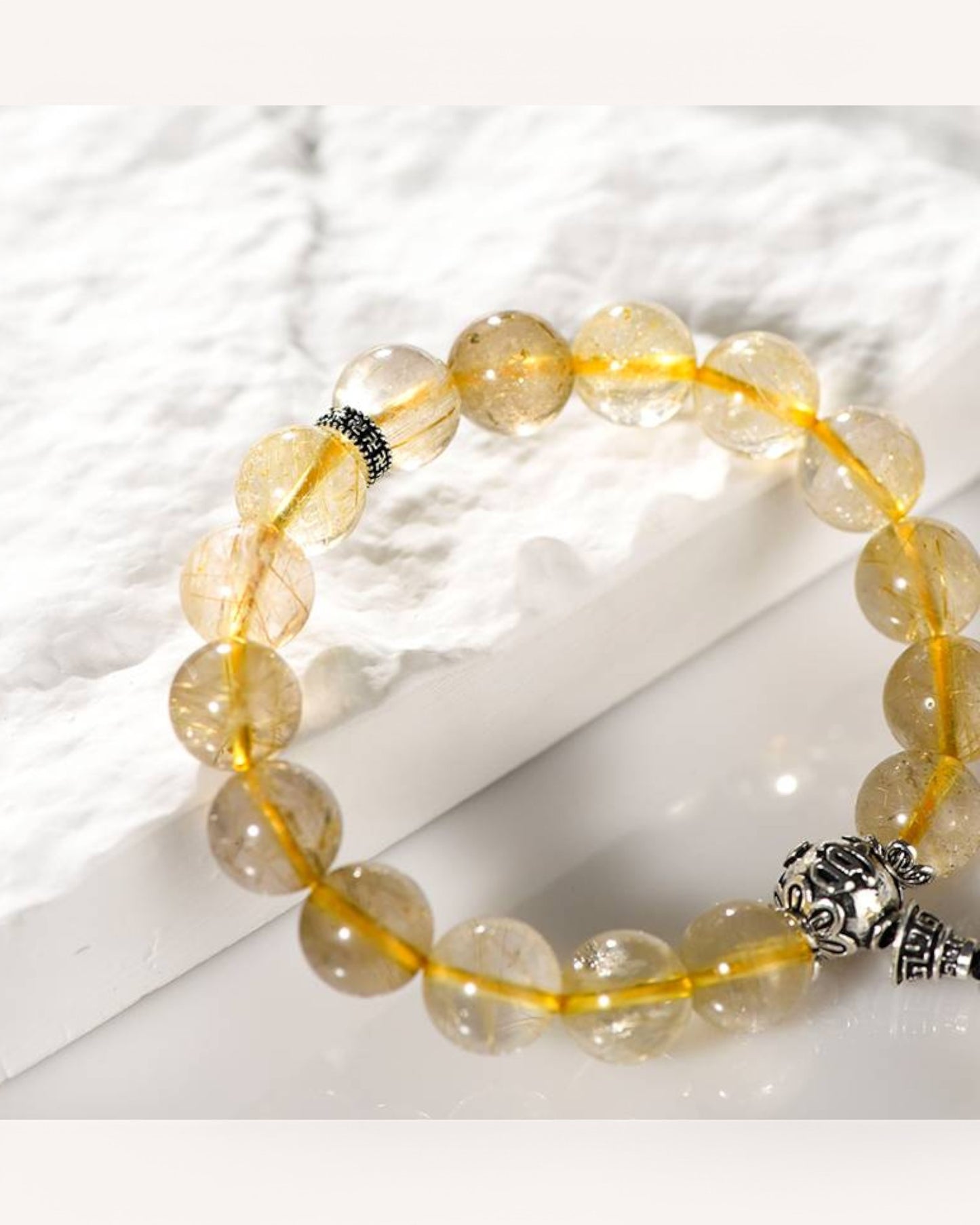 Healing Rutilated Quartz bracelet on light surface, symbolizing financial prosperity, goal-setting, and abundance.