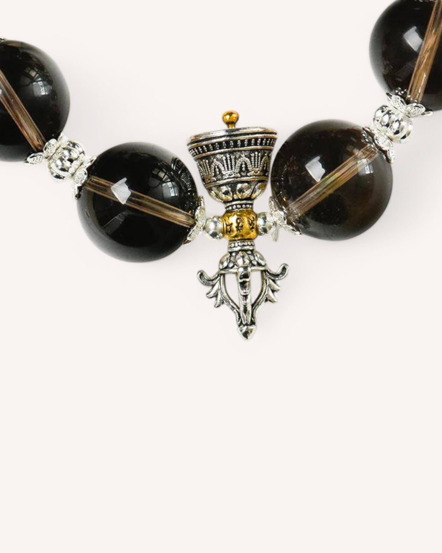 Close-up view of Smoky Quartz beads with silver accents, showcasing the natural texture and high-vibration protective energy properties.