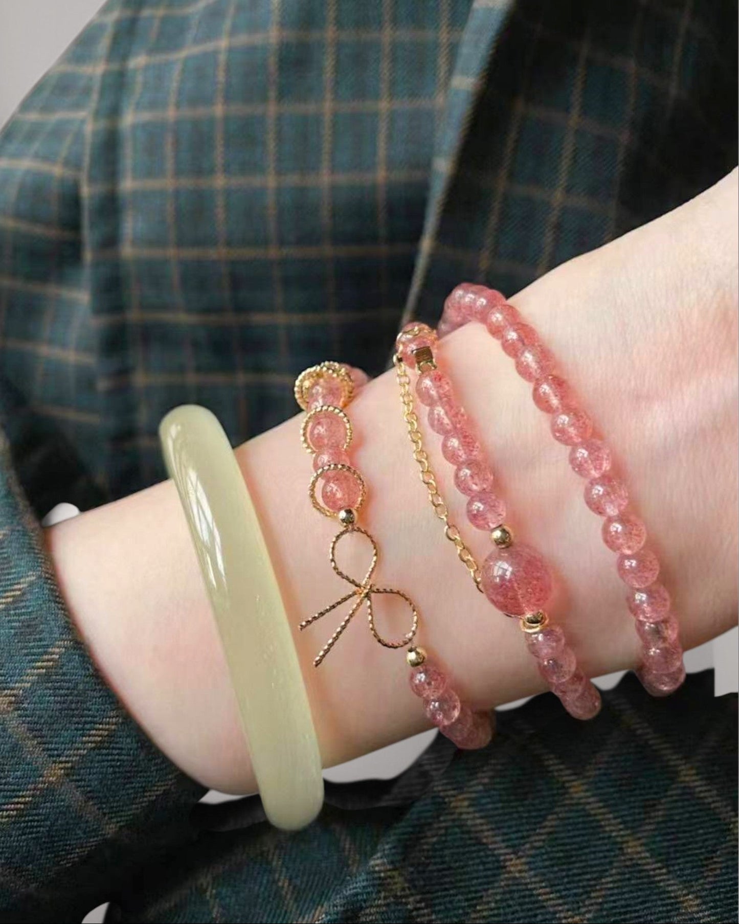 Strawberry Quartz bracelet stacked on wrist with gold and jade bangles, enhancing feminine energy, love, and emotional harmony.