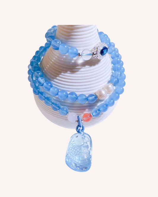 Woman wearing a calming Aquamarine crystal mala as a multi-strand bracelet – perfect for emotional balance and spiritual growth.