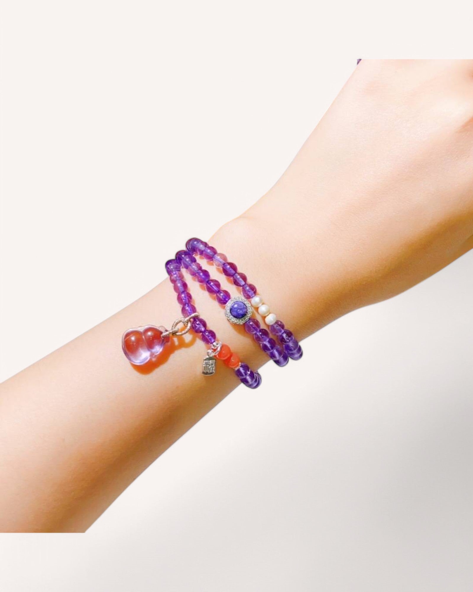 A close-up of a person wearing the Amethyst Triple-Wrap Bracelet, highlighting its deep purple hues and layered design. Perfect for stress relief, intuition, and spiritual awareness.