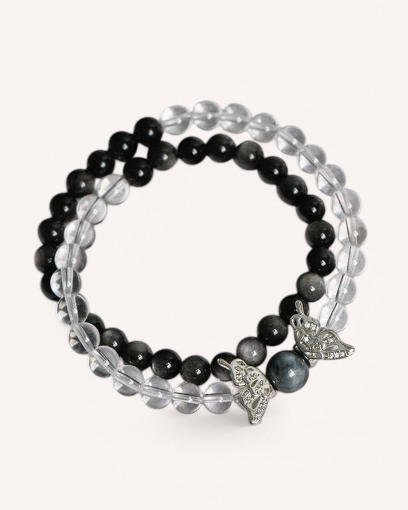 A stunning White Quartz and Obsidian bracelet with a silver butterfly charm, designed for energy protection, emotional balance, and spiritual clarity. The double-layered design enhances resilience and inner strength.