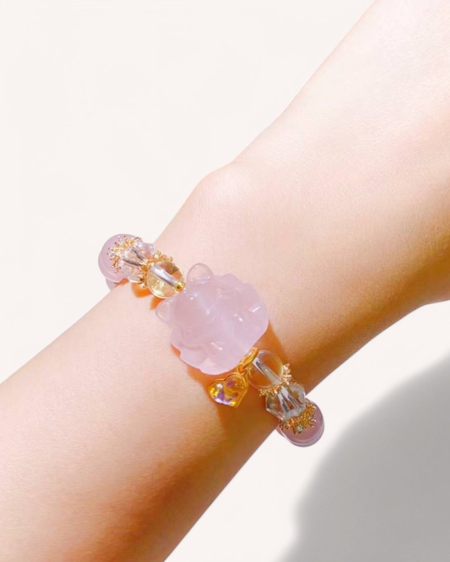 A close-up of a Love & Intuition Rose Quartz & Aquamarine Bracelet worn on the wrist, showcasing its delicate nine-tailed fox charm, gold accents, and crystal energy for emotional healing and clarity.