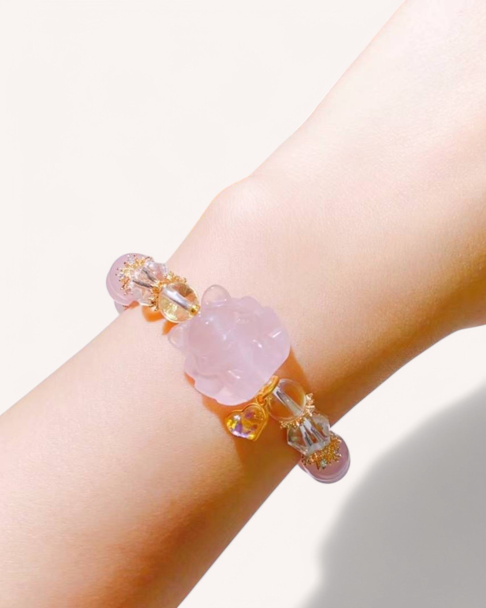 A close-up of a Love & Intuition Rose Quartz & Aquamarine Bracelet worn on the wrist, showcasing its delicate nine-tailed fox charm, gold accents, and crystal energy for emotional healing and clarity.