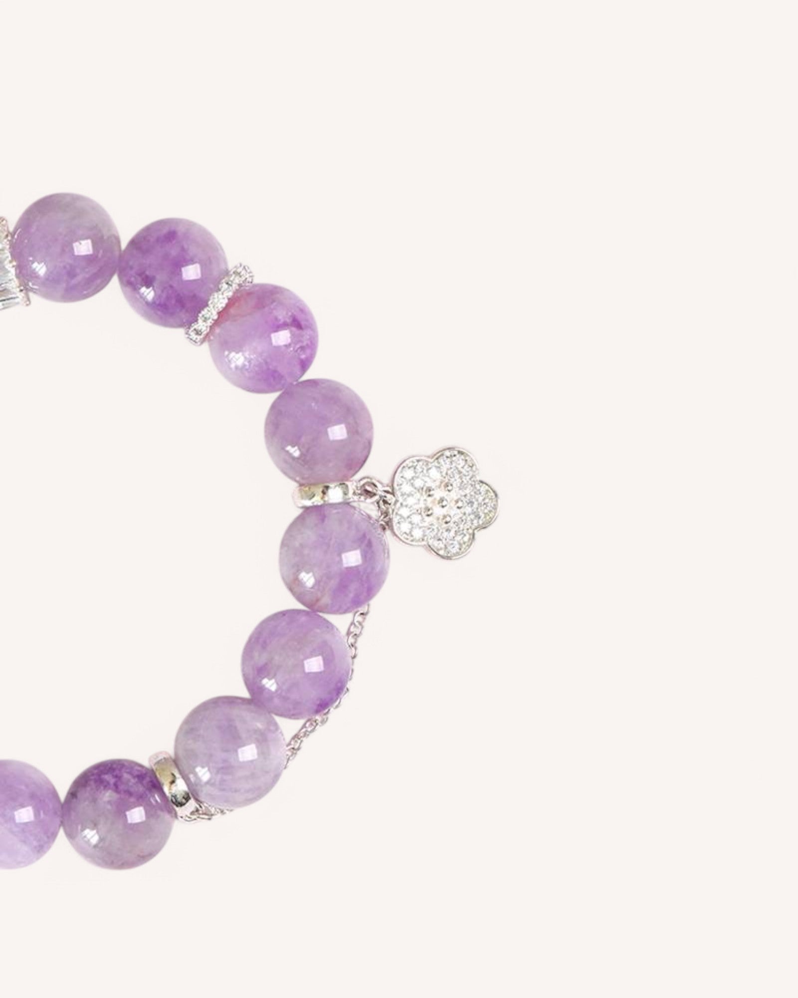 A close-up view of a Lavender Amethyst Bracelet with a delicate floral charm, designed to promote emotional balance, relaxation, and spiritual clarity.