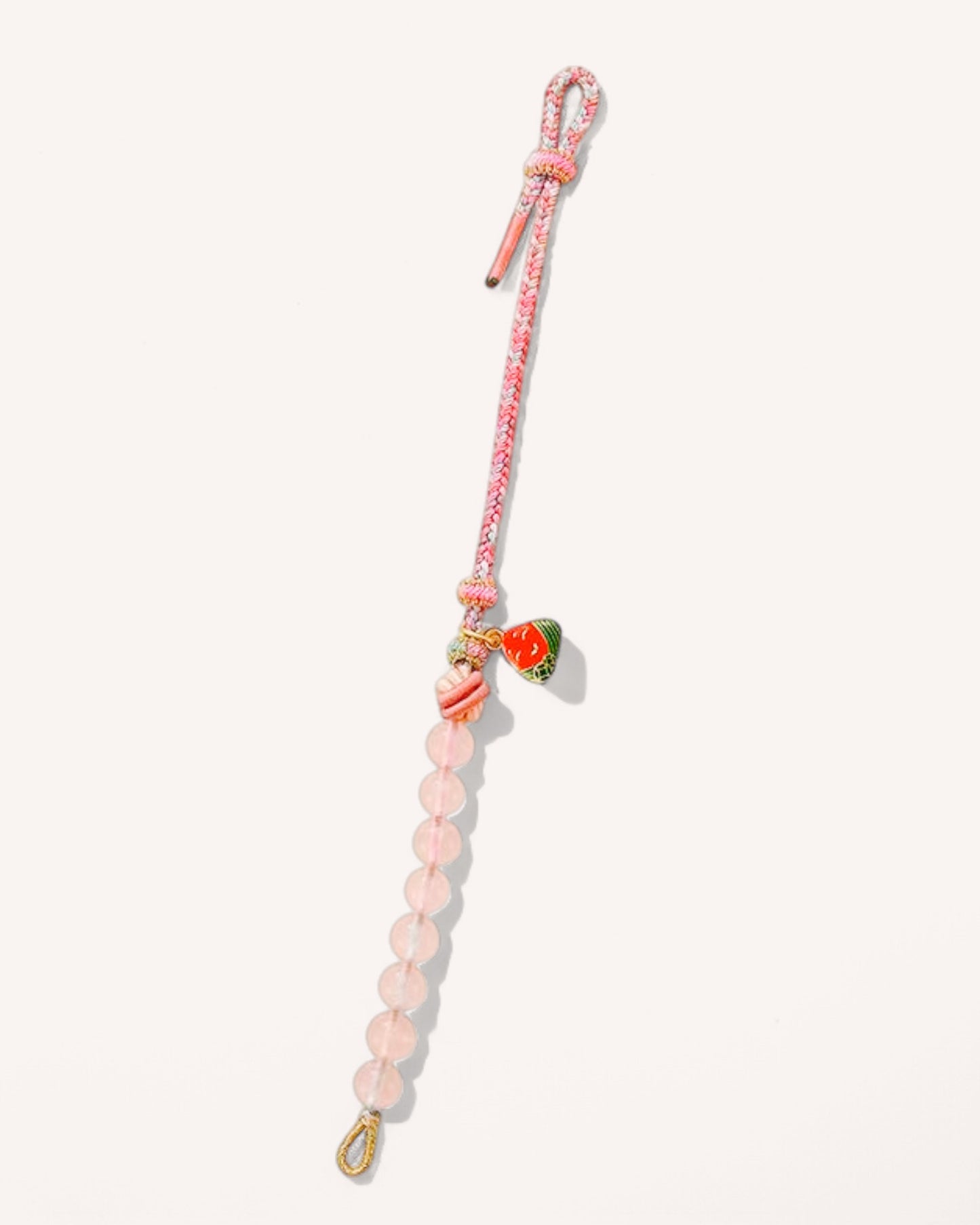 Extended view of the Rose Quartz Woven Bracelet, highlighting the pink woven cord, quartz beads, and symbolic charm for focus and stability.