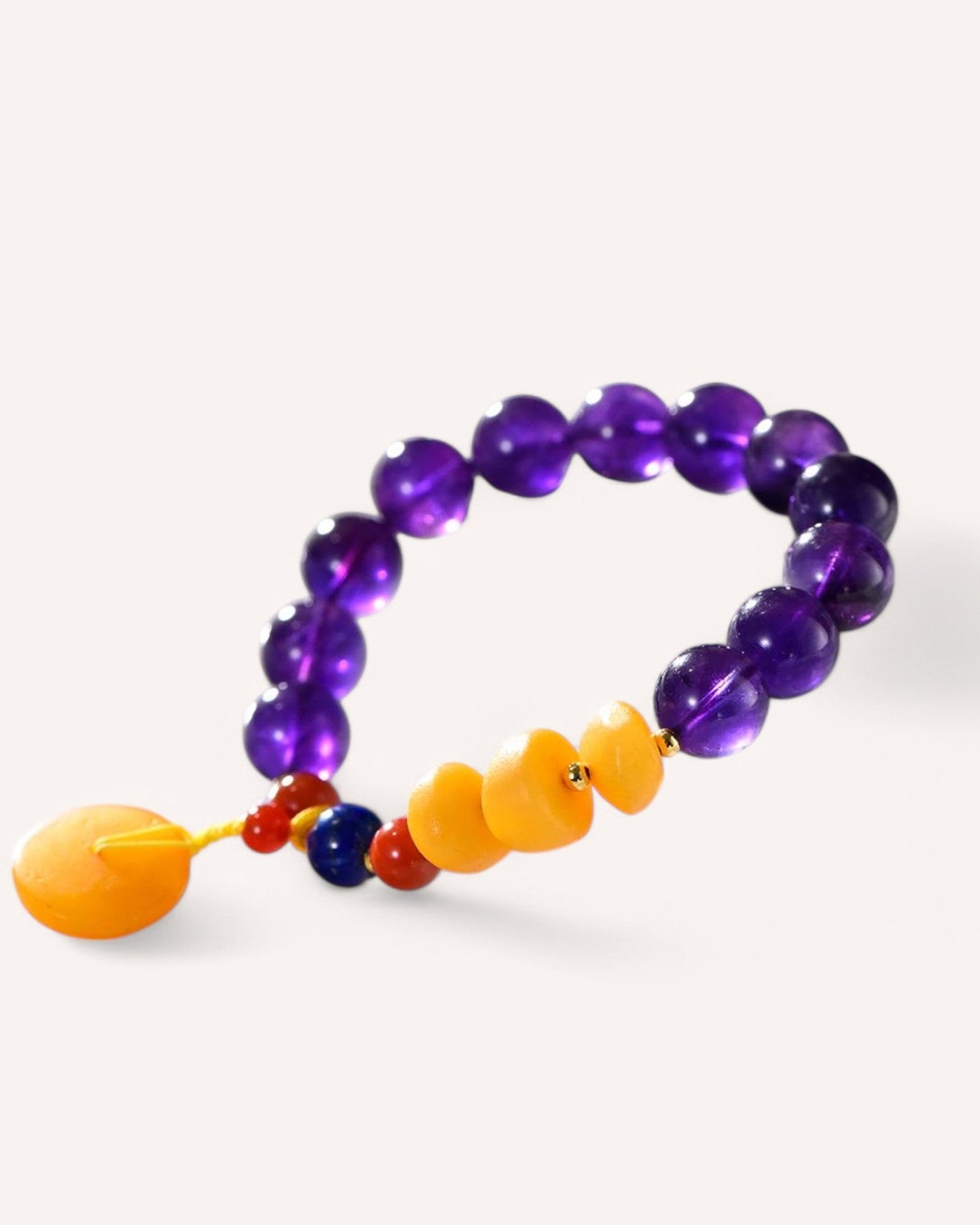 Side view of Amethyst and Honey Amber Healing Bracelet showcasing polished amethyst, honey amber, red agate, and lapis lazuli beads for energy, confidence, and spiritual growth.