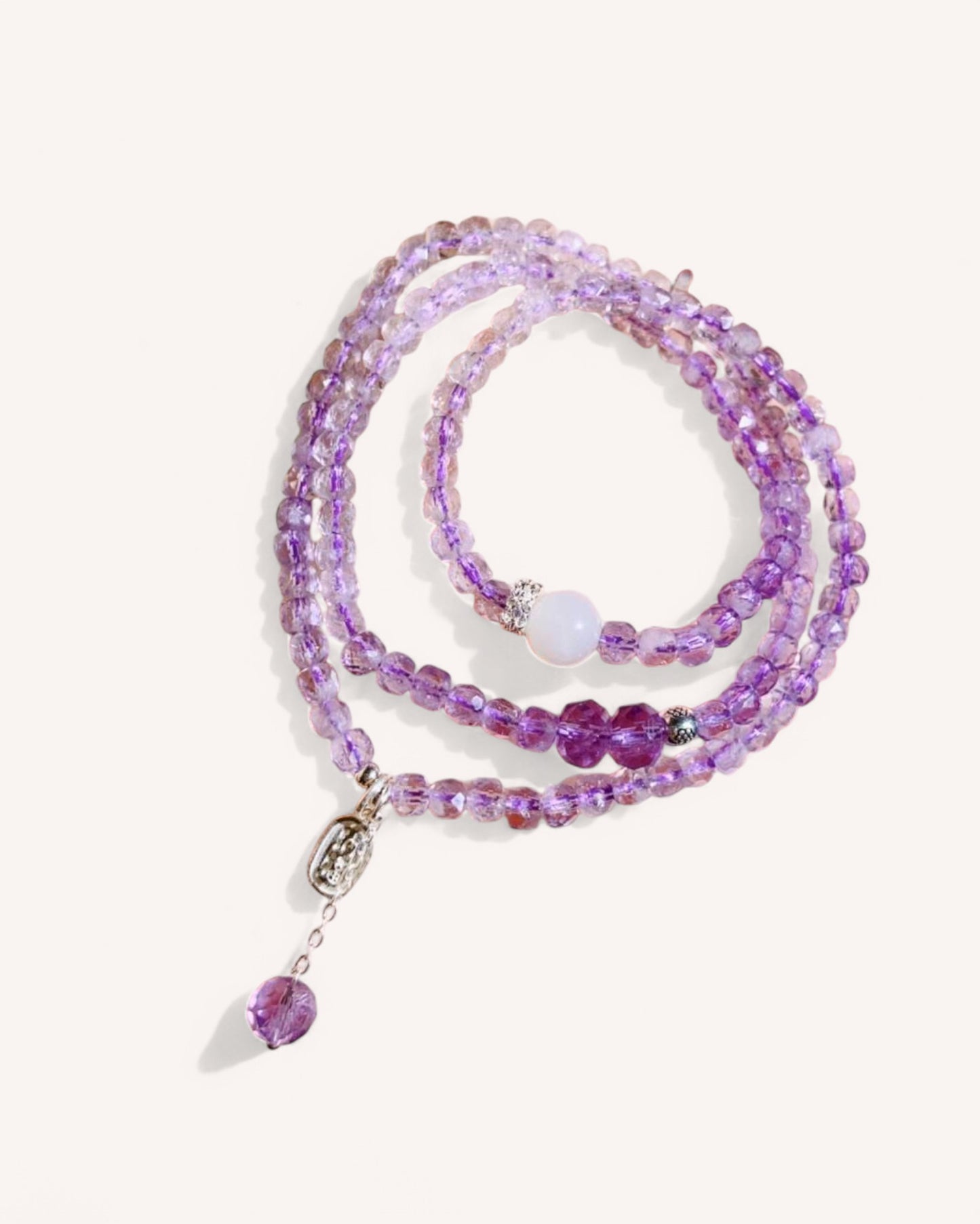 Triple-Wrap Amethyst Bracelet featuring premium amethyst beads with white jade and sterling silver accents. Designed for spiritual protection, emotional healing, and enhanced intuition. Showcased in a flat-lay view.