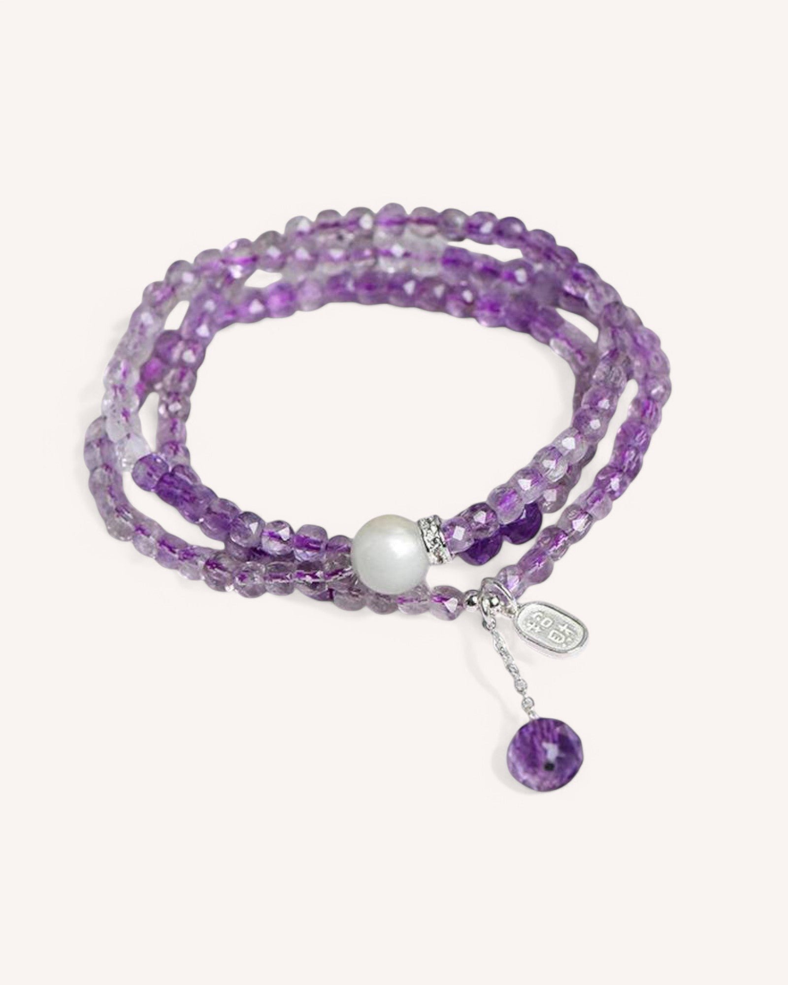Handcrafted amethyst wrap bracelet featuring faceted amethyst beads, a pearl accent, and sterling silver charms. Designed for spiritual healing, protection, and intuition enhancement.