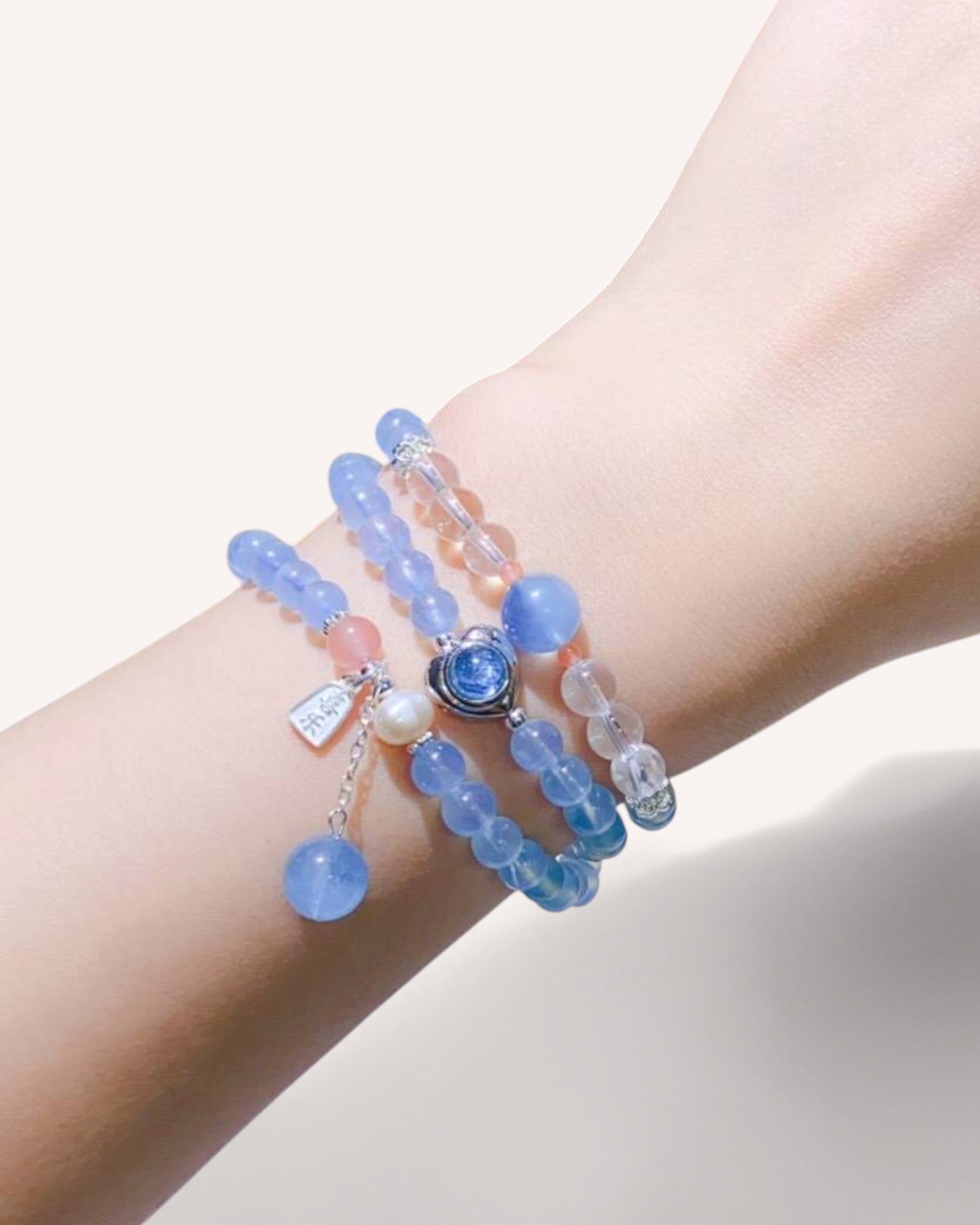 Aquamarine multilayer crystal wrap bracelet worn on wrist, promoting tranquility, clear communication, and emotional harmony.