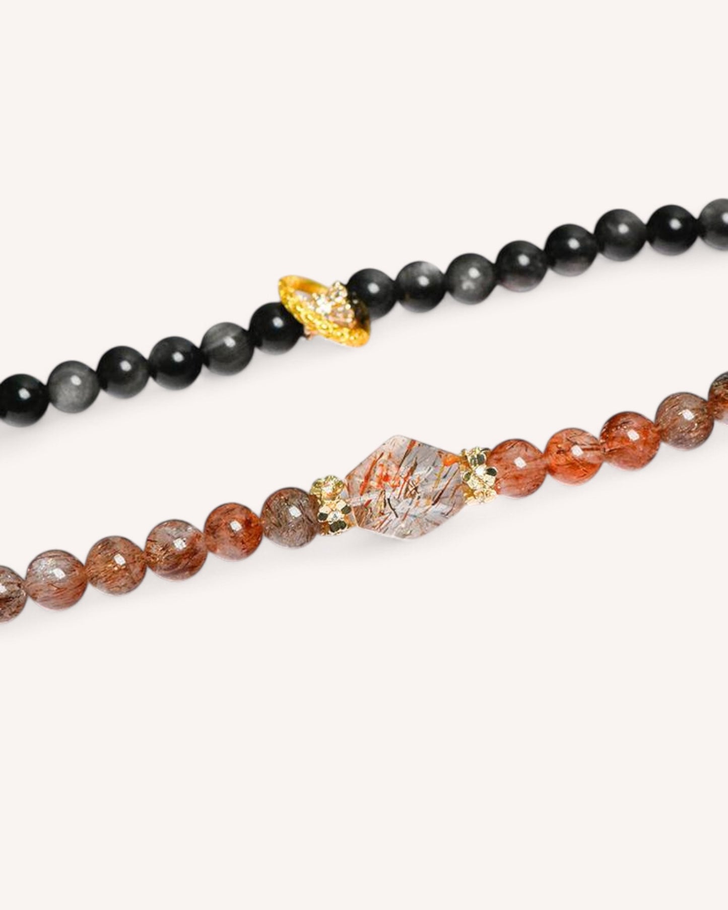 Close-up of Black Gold Super Seven and Obsidian crystal beads with gold alloy detailing for spiritual grounding