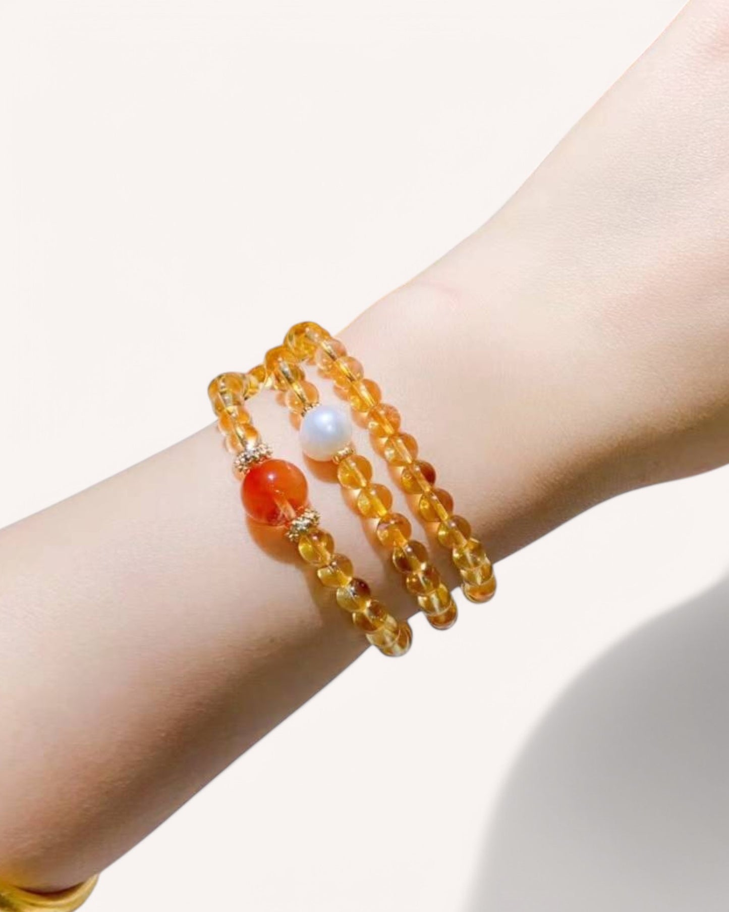 Citrine & Rutilated Quartz Multi-Layer Bracelet on Wrist – A stunning prosperity bracelet designed to attract wealth, boost confidence, and ignite passion. Features Pearl and Red Rabbit Hair Quartz for emotional balance and manifestation.