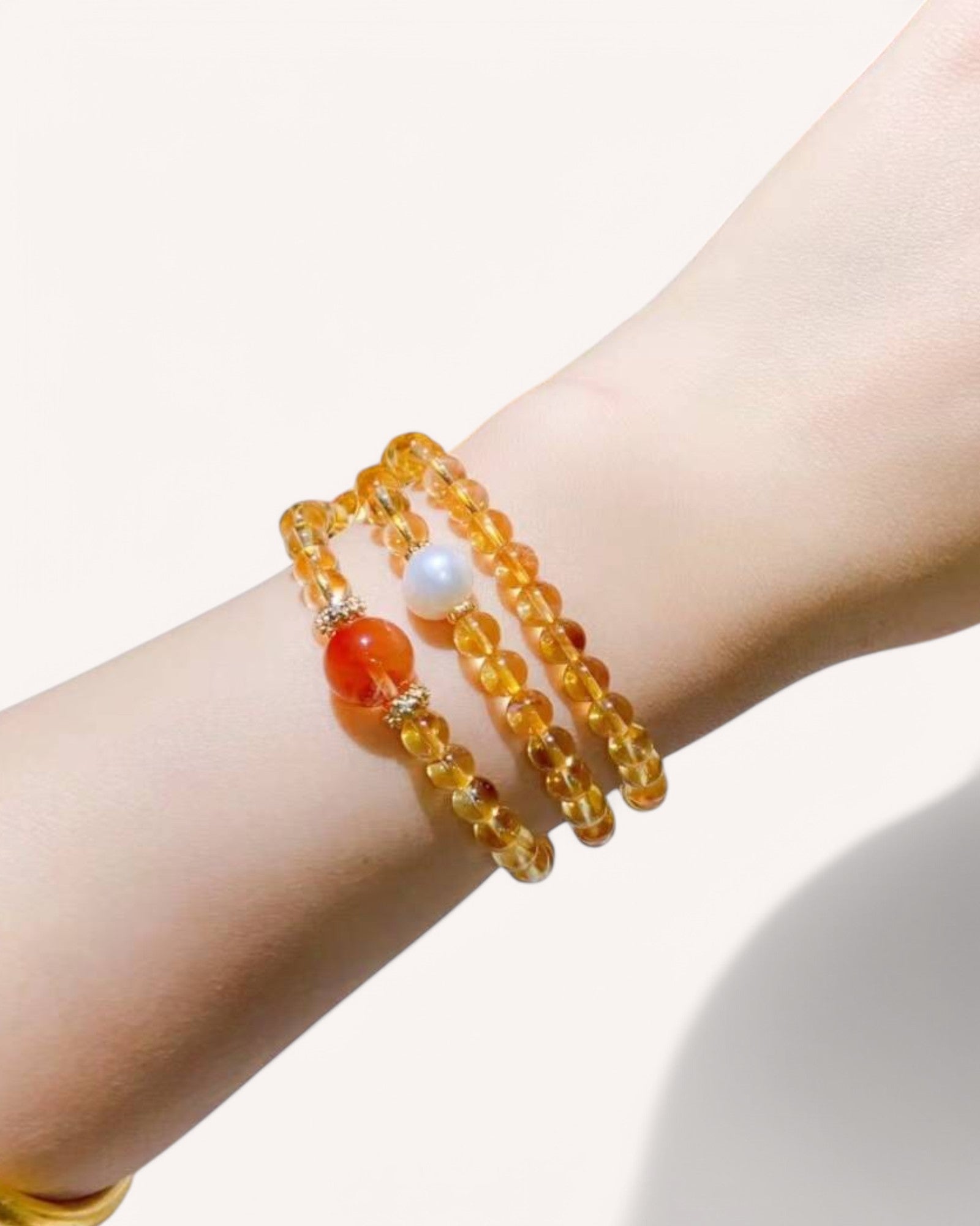 Citrine & Rutilated Quartz Multi-Layer Bracelet on Wrist – A stunning prosperity bracelet designed to attract wealth, boost confidence, and ignite passion. Features Pearl and Red Rabbit Hair Quartz for emotional balance and manifestation.