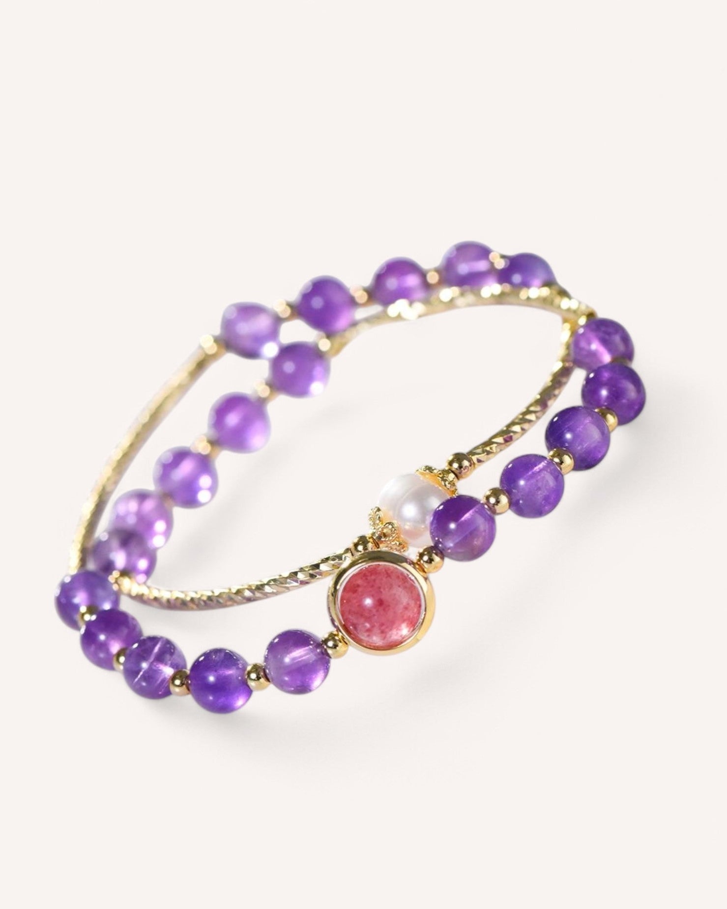 Amethyst and Strawberry Quartz wrap bracelet with natural pearls, designed to promote love, emotional healing, and inner balance. Elegant gold alloy accents enhance its refined style.