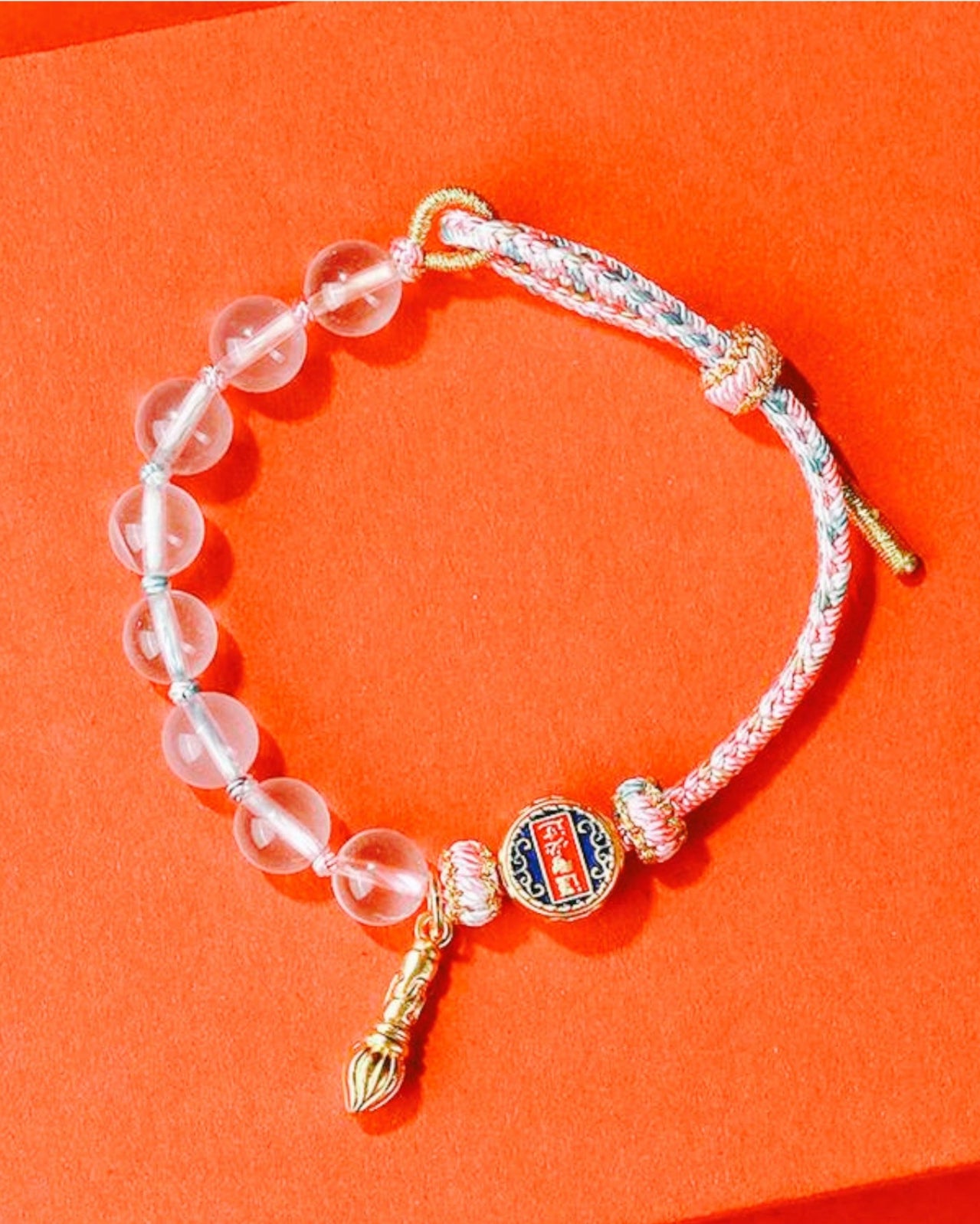 Fortune & Wisdom Rose Quartz Lucky Knot Bracelet featuring woven cord, gold-tone accents, and clear quartz beads, symbolizing good luck, emotional healing, and prosperity.
