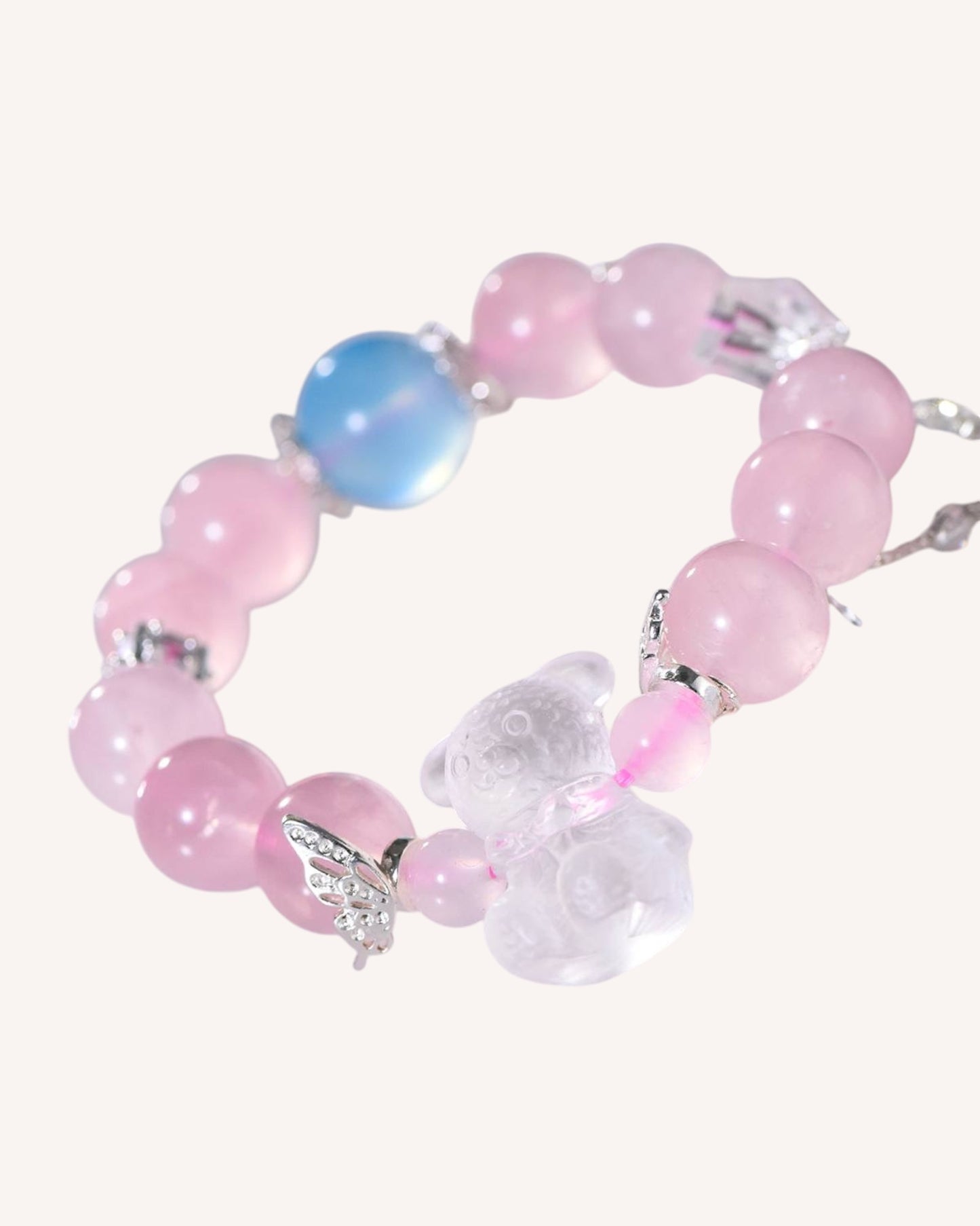 Angled display of rose quartz and aquamarine healing bracelet featuring silver charm and clear quartz for emotional balance and spiritual protection.