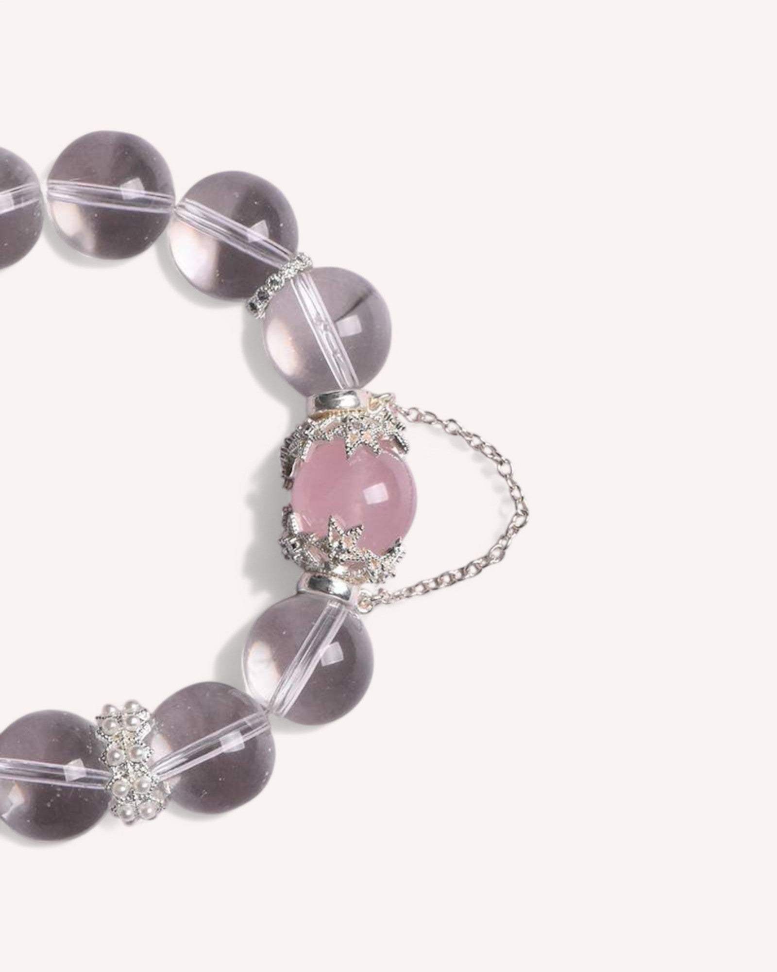 Side view of the Love & Clarity Rose Quartz Bracelet showcasing its transparent white crystal beads and delicate rose quartz charm, designed for emotional healing and positivity.