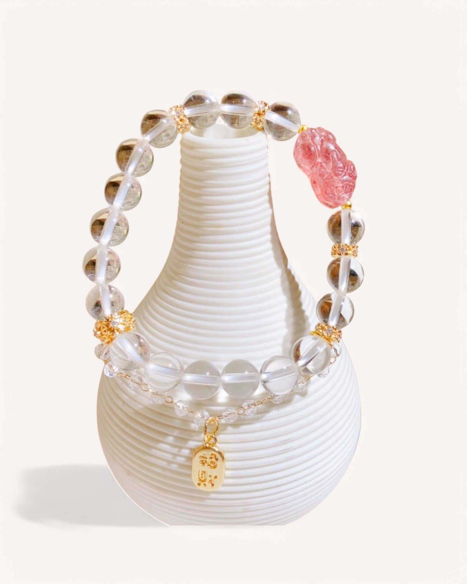 Love & Wealth Pixiu Bracelet featuring White Quartz & Strawberry Quartz for prosperity, attraction, and emotional healing, displayed on a minimalist vase.