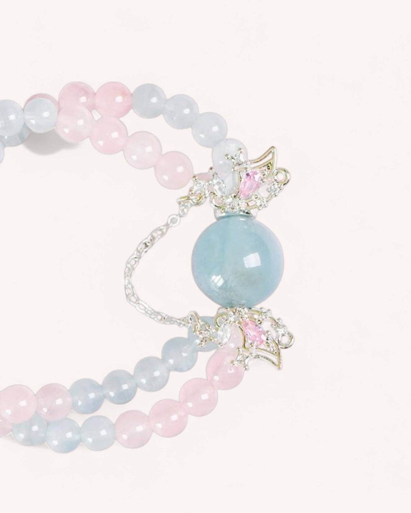 Close-up of the Serenity & Love Aquamarine & Rose Quartz Butterfly Bracelet, featuring a large aquamarine bead with elegant butterfly wing details.